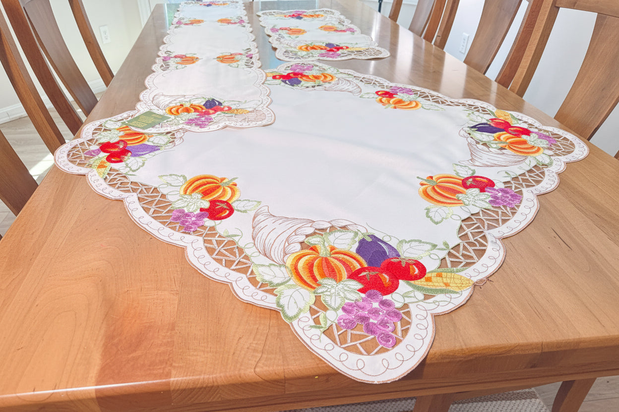Decorative table runner with embroidered designs on a wooden table.